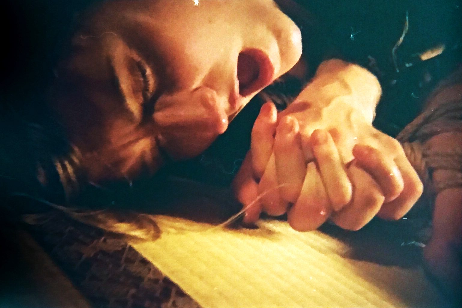 A person with an intense facial expression. Hands visible.